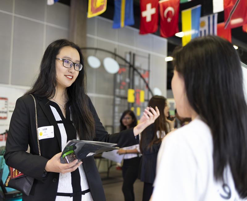 A student speaks with a potential employer at a career fair. 